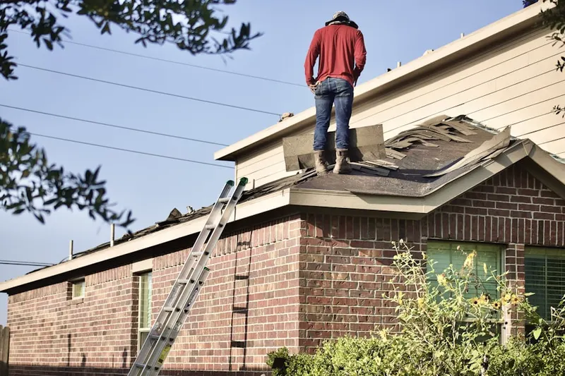 Professional roofer working on a residential roof in De Soto Village